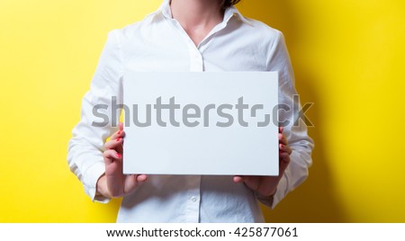 photo of beautiful young woman with board on the yellow background