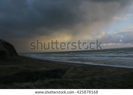 Underexposed picture of an incoming storm on the coast of New Zealand.The underexposure is a key element to the picture because it shows the threat of the storm and giving a painting-like effect.