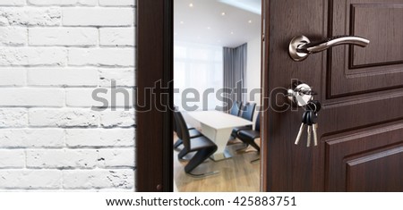 Half opened door to a cabinet or office. Door handle, door lock. Lounge door half open. Opening door. Privacy, welcome concept. Entrance to the room. Door at white brick wall, modern interior design.