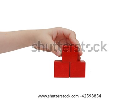 Child hand make a building with red blocks isolated on white