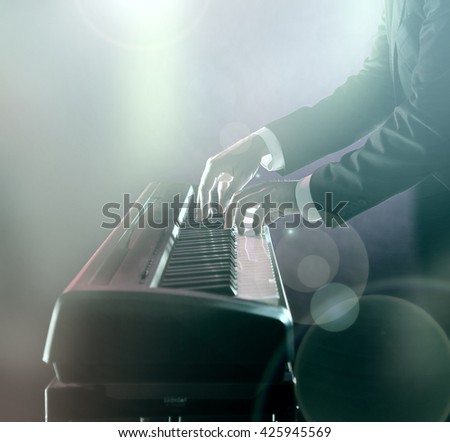 Man playing on electronic musical keyboard, close-up.