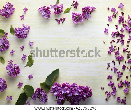 Floral border Beautiful fresh lilacs  flowers on a yellow background top view.