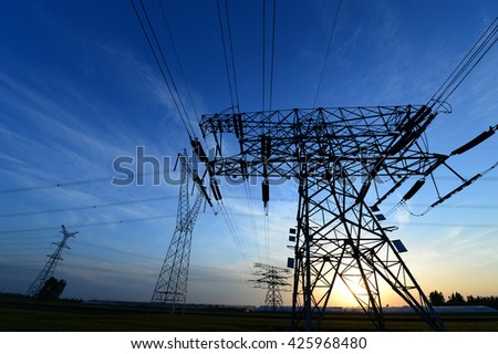 High voltage towers under the setting sun 
