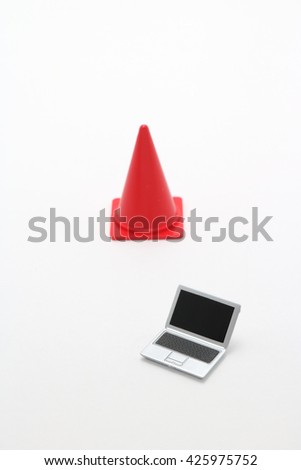 Laptop and safety cone.
Miniature notebook PC and safety cone on white background.