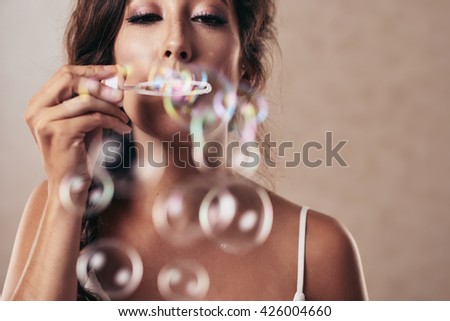 Close-up image of girl blowing bubbles, selective focus