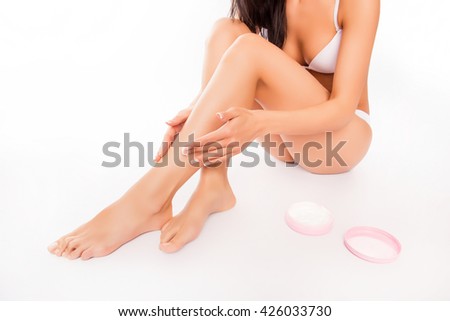 Close up photo of smooth woman's legs with applied cream