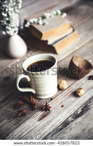 Large Cup of coffee on vintage wooden background. Spring flowers and books.