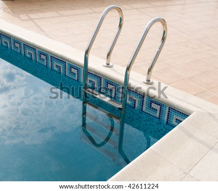 View of swimming pool with ladder and landscape on background