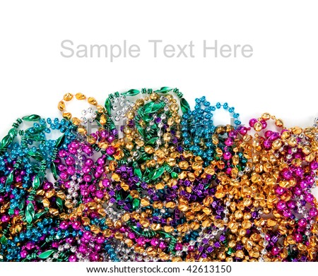 Multi colored mardi gras beads including blue, green, purple, pink, yellow and gold on a white background with copy space