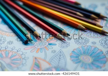 Image of woman coloring, adult coloring book trend, for stress relief. top view. colorer - antistress with colored pencils. Adult coloring books. The woman draws thereby relieves stress