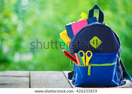 Full School backpack on wooden and nature background Royalty-Free Stock Photo #426235819