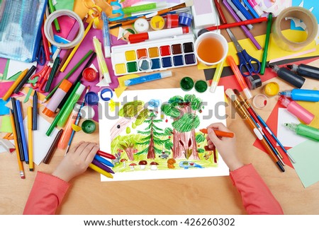 forest and wildlife animals child drawing, top view hands with pencil painting picture on paper, artwork workplace