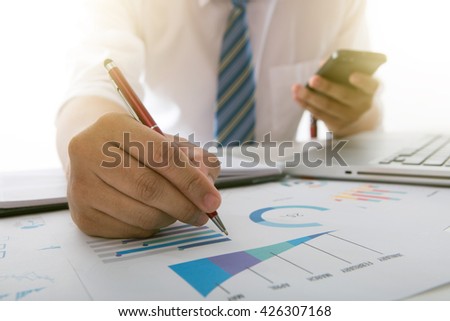 Silhouette of cropped shot of businessman hand working with new modern computer and business strategy as concept