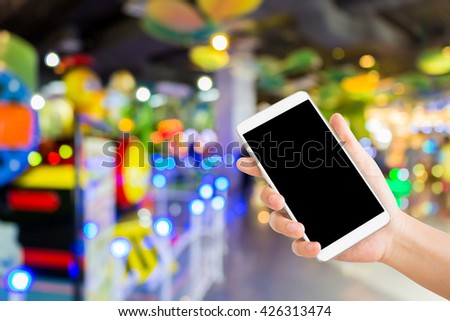 woman use mobile phone and blurred image of play zone in the mall with beautiful bokeh