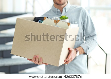 Businessman with moving box in office Royalty-Free Stock Photo #426337876