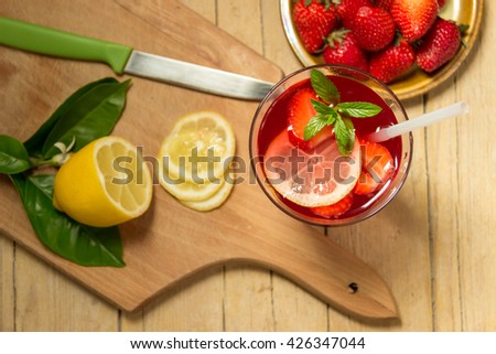 Glass of freshness lemonade with strawberries and mint , on the wooden background