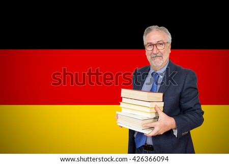 Senior teacher standing before of the german flag