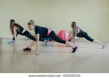 Beautiful girls spend aerobics morning exercises in a fitness room