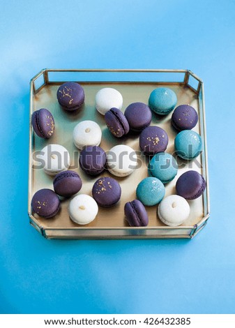 Lavender macaron on a tray. Blue background. Selective focus. Natural light.