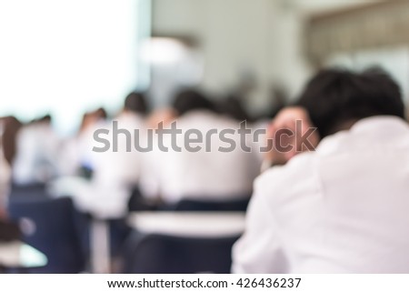 Blur abstract background school student in uniform seriously sitting on seat in class focus on learning thinking studying hard