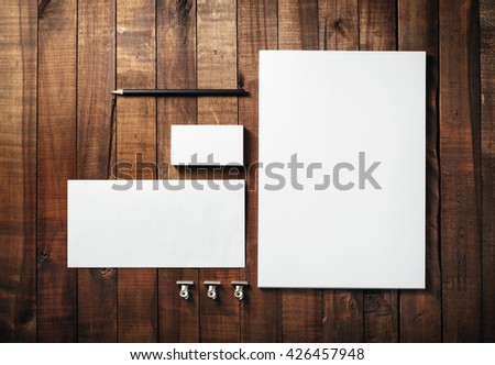 Blank stationery set on wood table background. Corporate identity template. Letterhead, business cards, envelope and pencil. Mock-up for branding identity for designers. Top view.