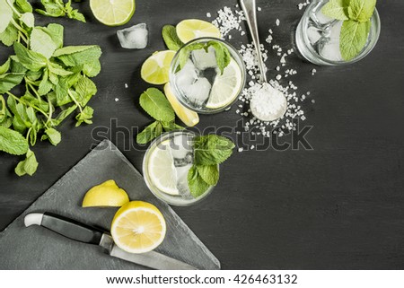 drink mojitos in the process of preparation on a dark table top view