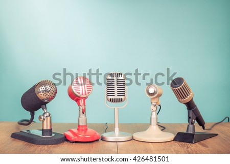 Retro old microphones for press conference or interview on table. Vintage style filtered photo Royalty-Free Stock Photo #426481501