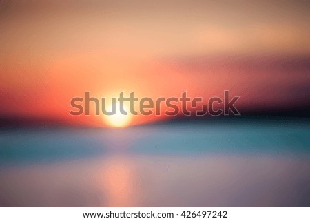 Blurry background of a picturesque view of a beautiful sunset over a river. Cloudy colorful sky.