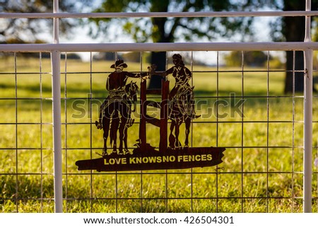 Love knows no fences sign on a fence in a ranch in the beautiful Texas Hill Country.