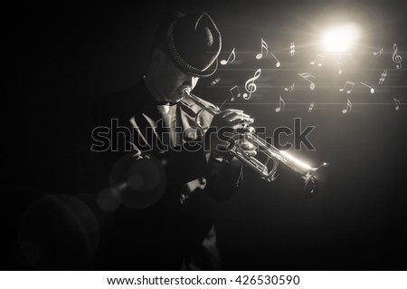 Musician playing the Trumpet with spot light and len flare with music notes on the stage