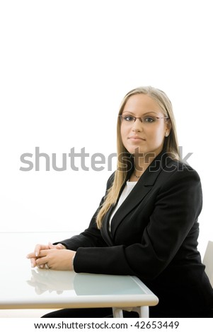 Young happy businesswoman sitting at office desk, smiling. Isolated on white background.