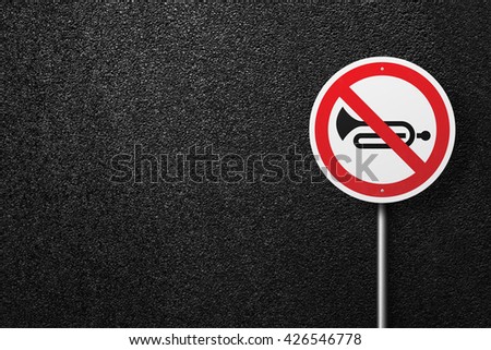 Road sign circular shape with a picture of the musical instrument on a background of asphalt. The texture of the tarmac, top view.