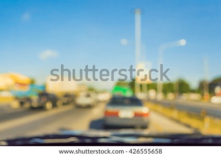 blur image of people driving car on day time for background usage . (take photo from inside)