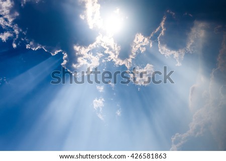Sunbeam through the haze on blue sky, clouds with sun rays