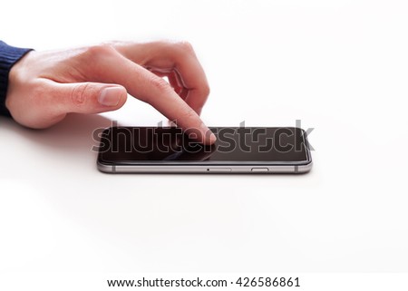 Hand using  smart mobile phone on wooden table and light blurred background