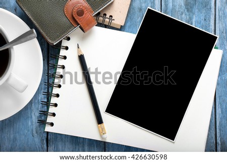 empty photo frames and notebook on wooden table