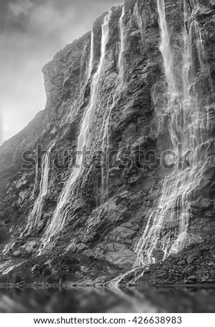 Geiranger fjord. Seven Sisters waterfall at magnificent sunset in Norway. Black and white vintage picture