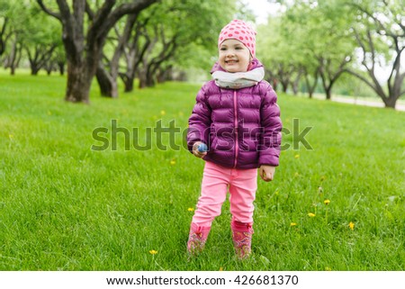 Beautiful girl standing on the grass in the spring park
