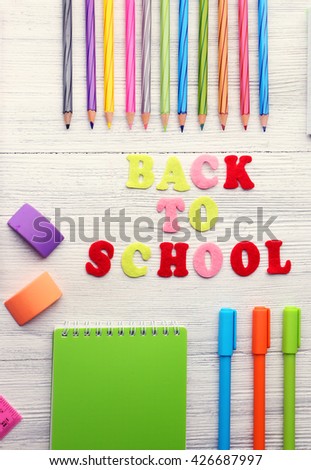 School set with back to school inscription, notebooks on light wooden background