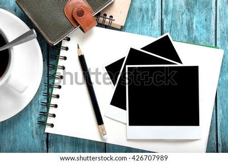 empty photo frames and notebook on wooden table