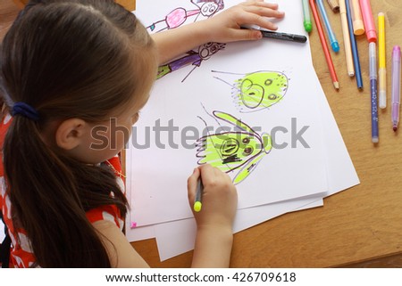Girl in red dress draws a picture of the family. children's fears, bad dreams, nightmares. 
