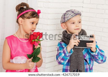 girl with flower and boy with camera, look away
