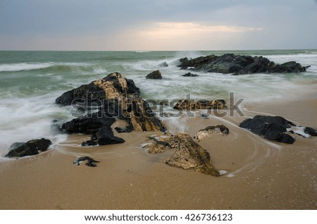 Rocks and ocean water flowing over them taken with slow shutter speed.samila beach,Songkhla Thailand.