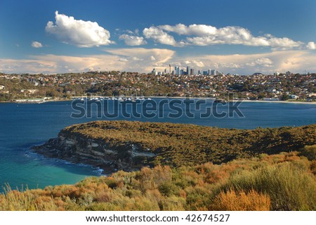 A view on beautiful Sydney skyline with an ocean bay in foreground