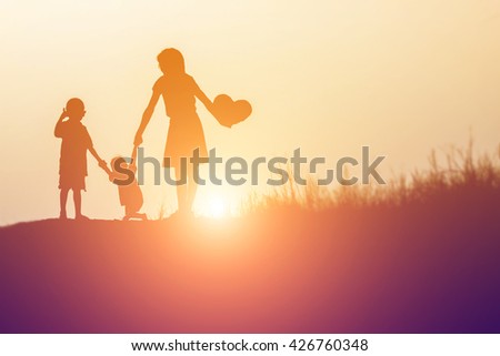 Silhouettes of happy parents having good time with their little 