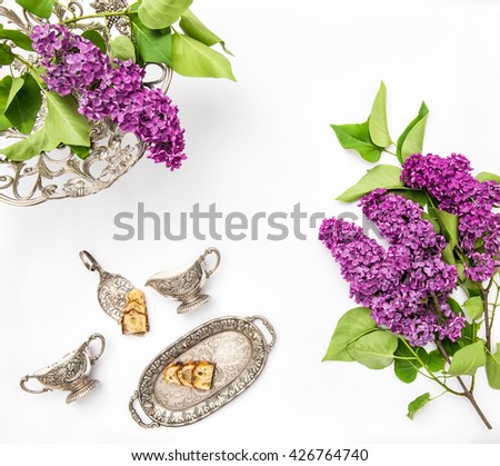 Lilac flowers. Coffee tea pie table dishes. Flat lay background. Top view
