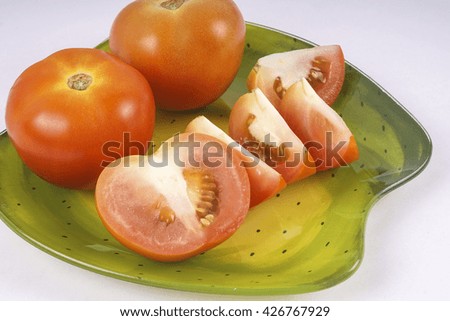 Tomato and its slice isolated on white. DOF and copy space