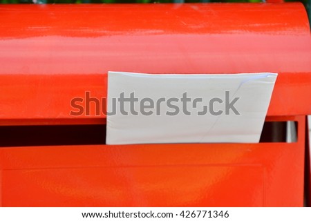 letter in red post box on home fence