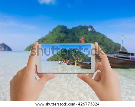 woman use mobile phone take a photo of the beach in Krabi Thailand