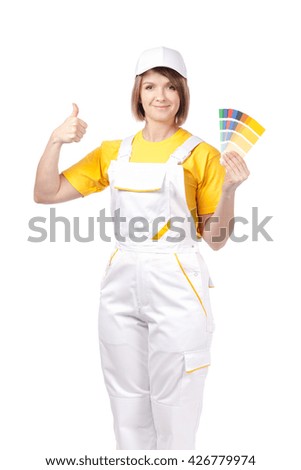 smiling female painter or decorator with color swatches showing thumb up isolated on white background. advertisement gesture